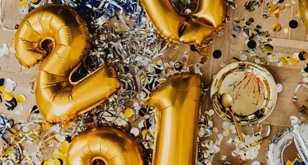 Close-up of gold and silver balloons with confetti, perfect for a festive celebration.